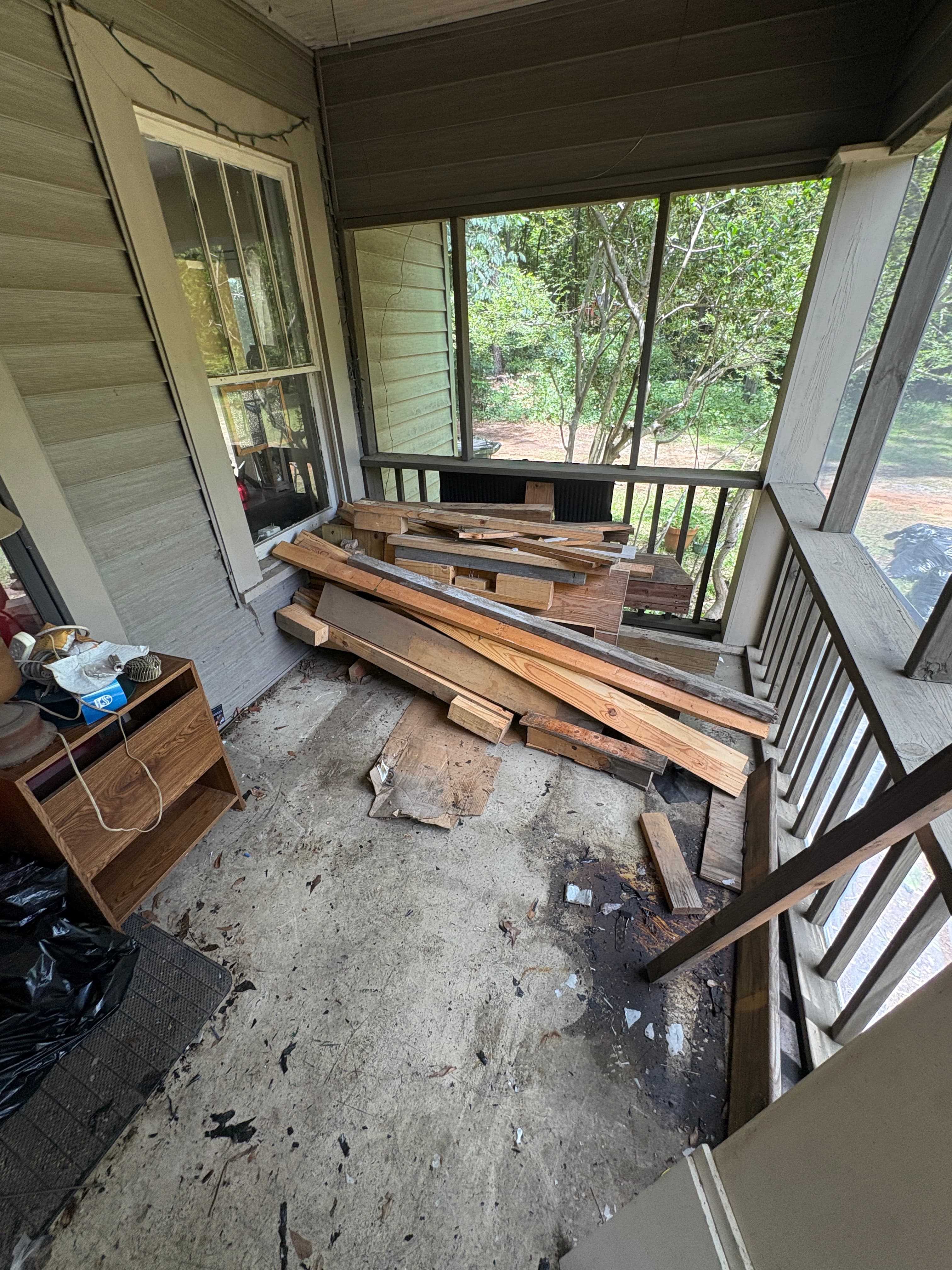 Cluttered porch stacked with junk before removal in Tuscaloosa