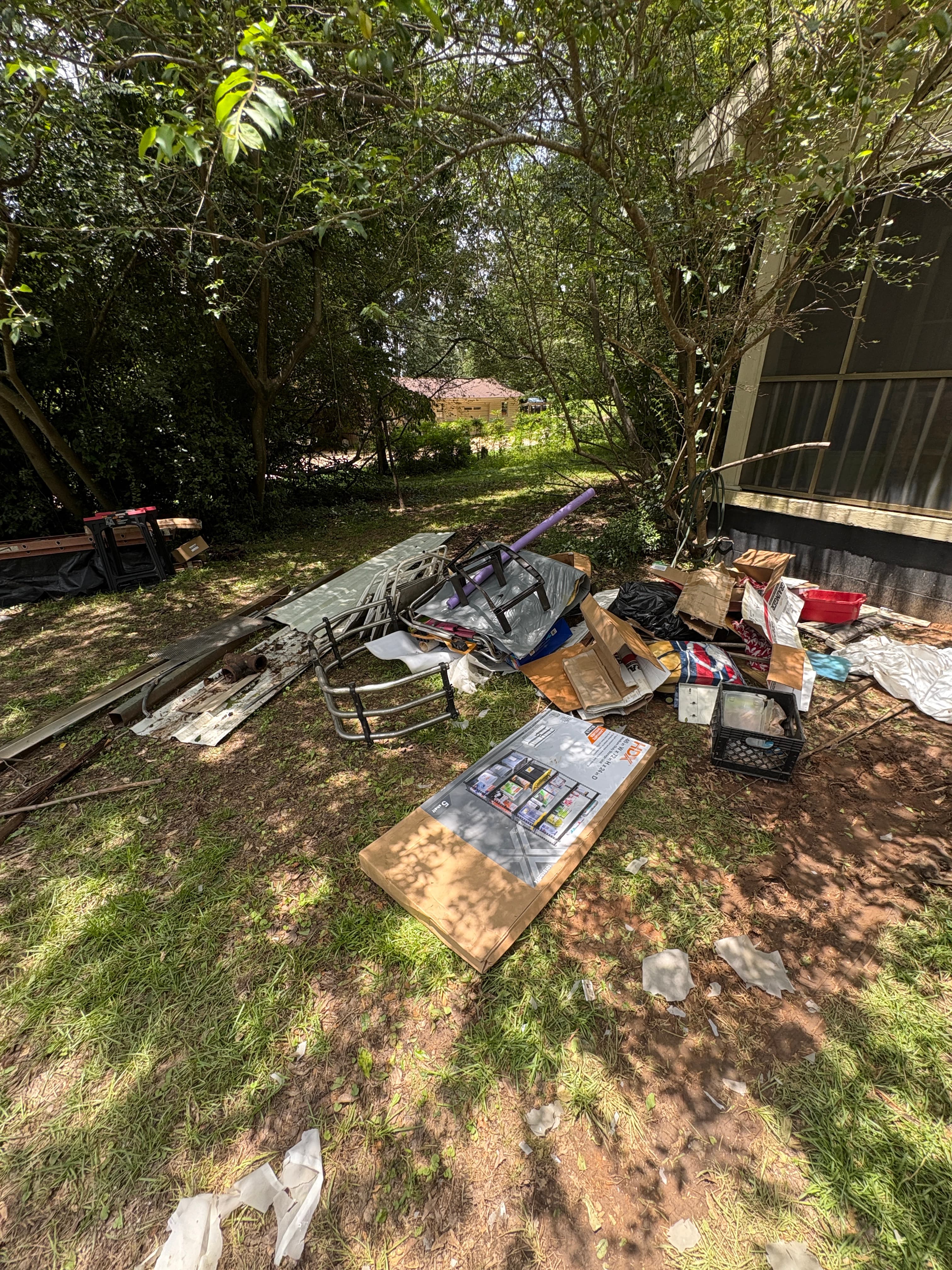 Yard covered in junk and debris before removal in Tuscaloosa, AL